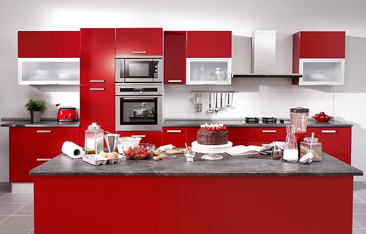 Red Kitchen Ideas; a kitchen design featuring a blend of white and red cabinets with stainless steel oven
