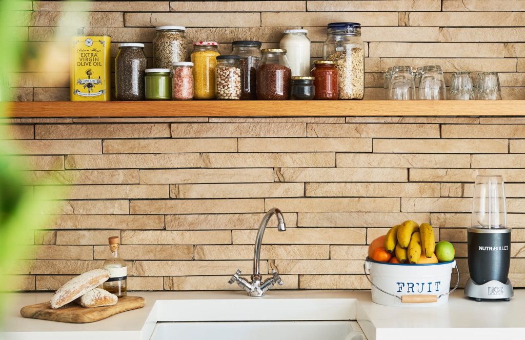 vintage features for your kitchen; a wood designed backsplash with a wooden shelf over a kitchen sink