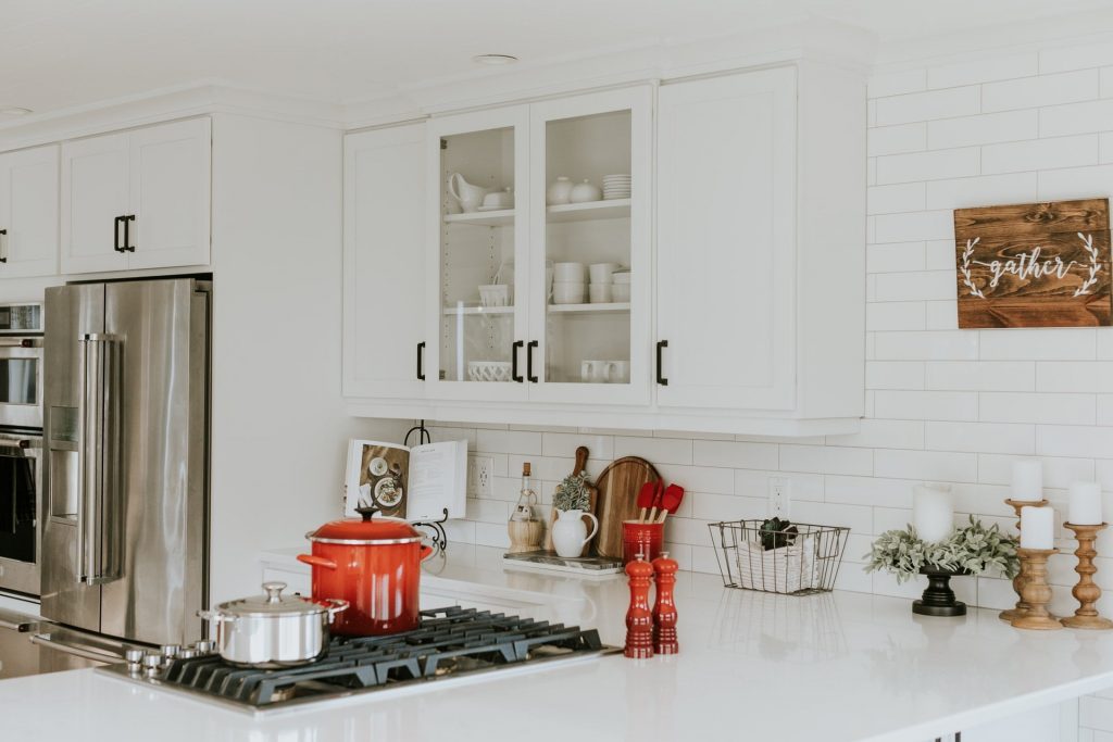 white kitchen cabinets done in a minimalist manner, red crockery for the perfect transitional kitchen
