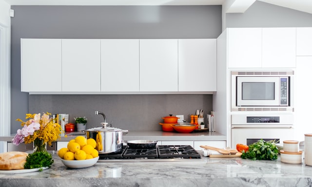 Countertop design ideas; modern kitchen featuring white cabinets and lots of produce on the countertop