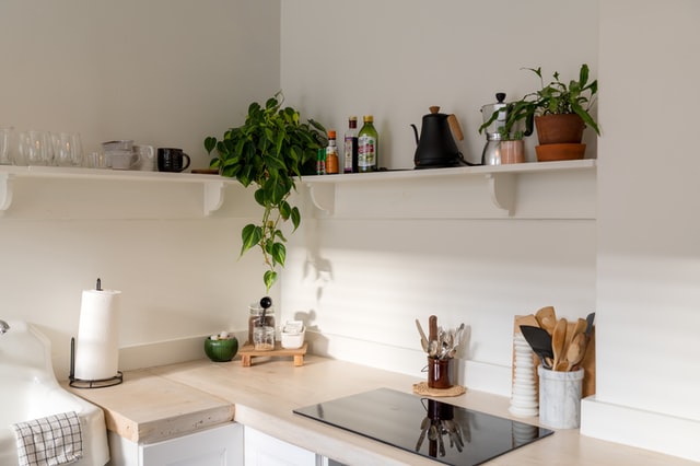 an all white kitchen featuring open shelves