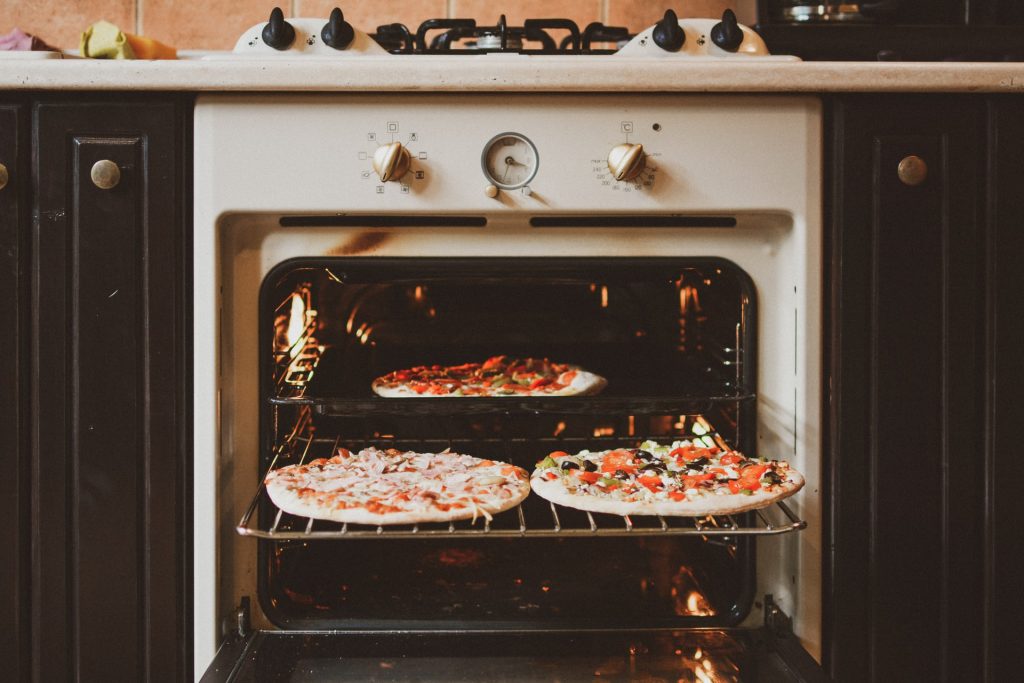 A vintage-style oven with three pizzas in it highlight how it can create the perfect retro design kitchen