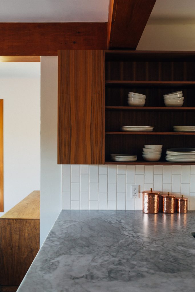 minimalist kitchen design with cabinets and shelves stored with plates and metal jars