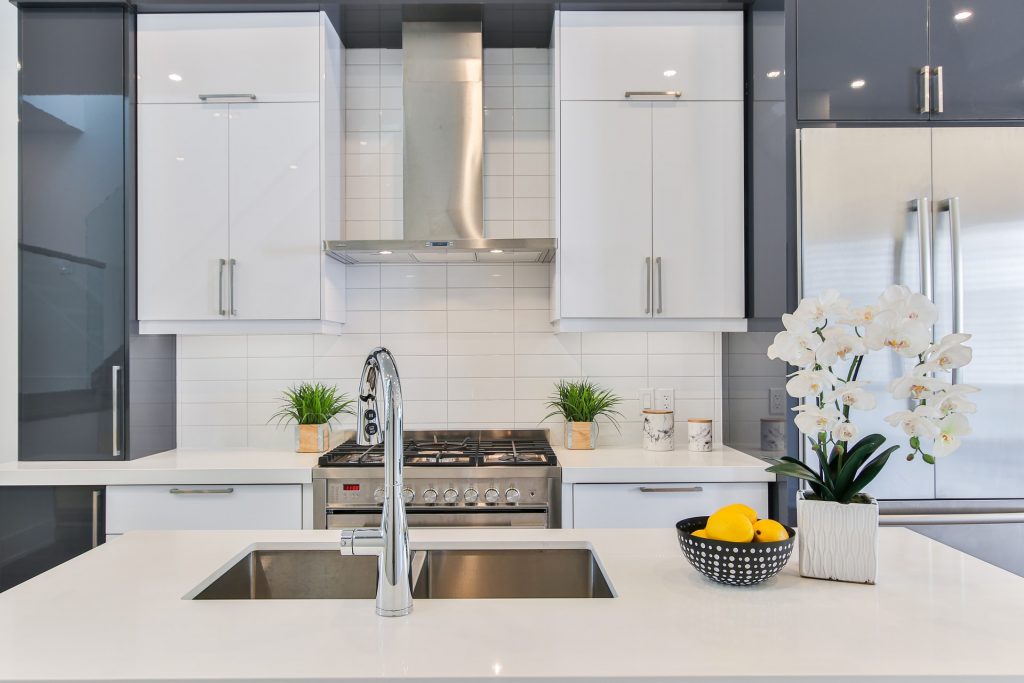 white splash back tiles with cooking hood and cabinets designed in a clean geometric line